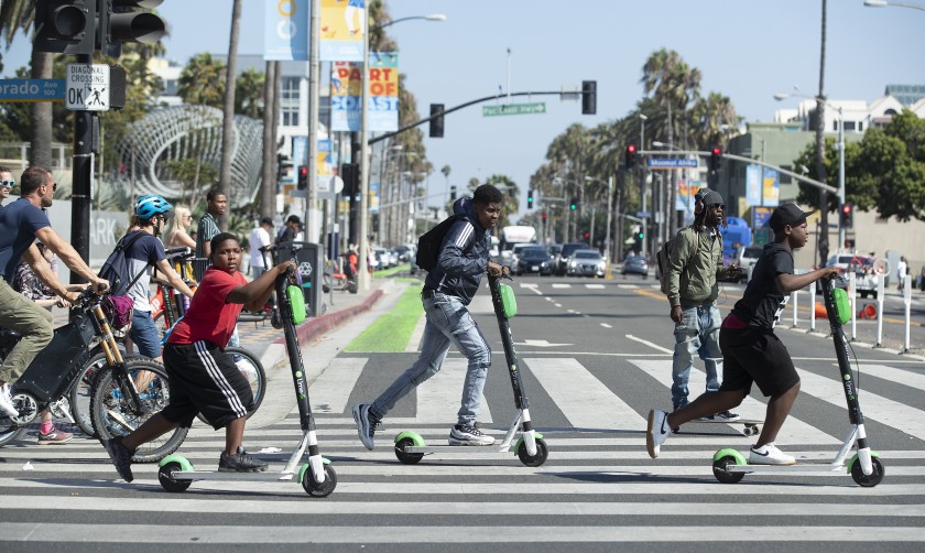  Люди, ездящие на скутерах с лаймом на пешеходном переходе в Санта-Монике "width =" 840 "высота =" 502 "/> 

<div class=