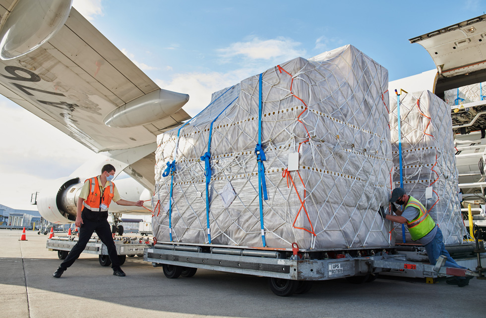 Сотрудники UPS Worldport перевозят поддоны с грузами iPhone 12, iPhone 12 Pro и iPad Air с самолета.