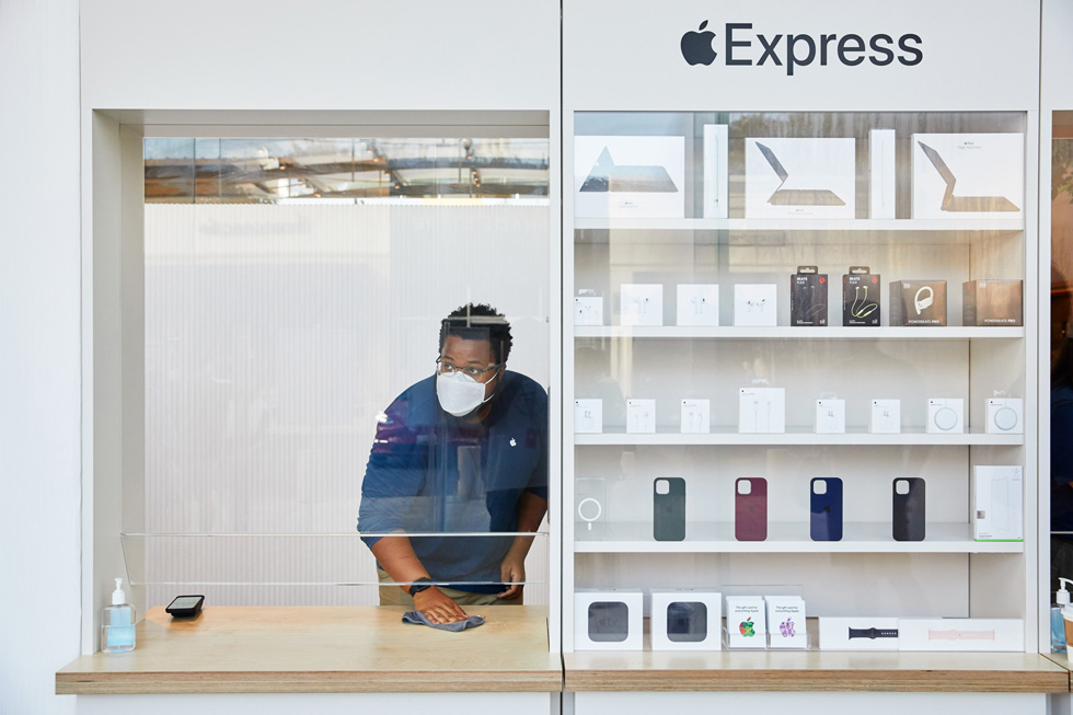 Сотрудник Apple вытирает витрину магазина Express в Apple Highland Village.