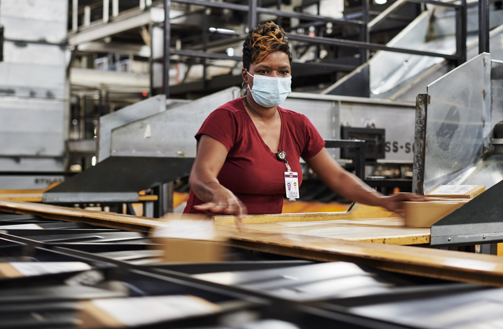 Сотрудник UPS Worldport сортирует посылки Apple для доставки.