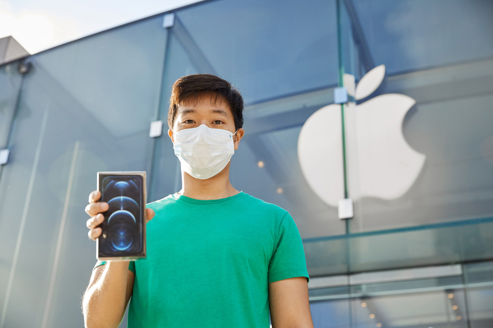 Покупатель за пределами Apple Highland Village демонстрирует свою новую покупку.