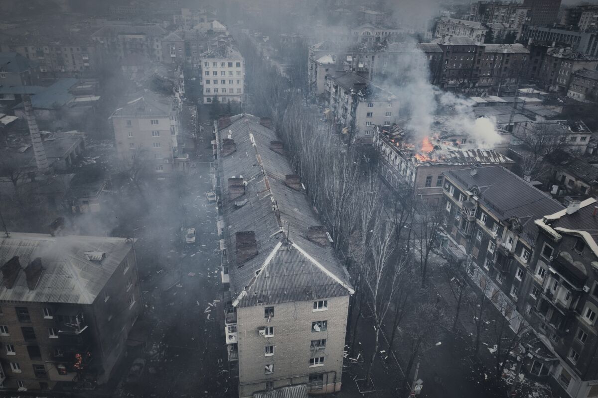 Воздушный кадр города с дымом поднимается от горящих многоквартирных домов 