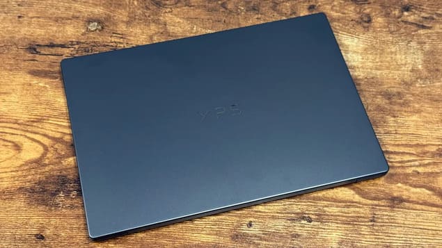 Закрытая крышка Dell XPS 14 с логотипом XPS на деревянном столе